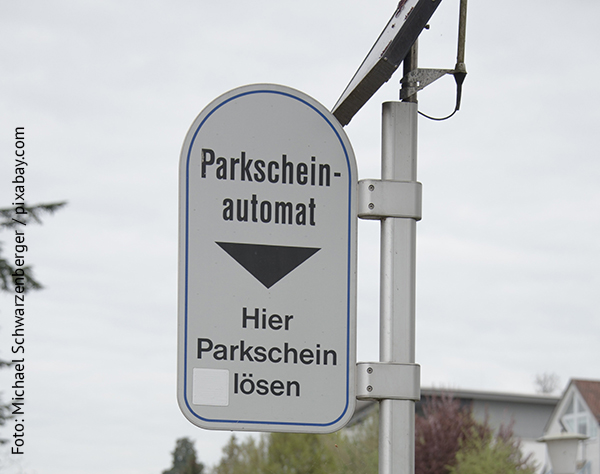 Ein Schild auf dem Parkscheinautomat steht. 