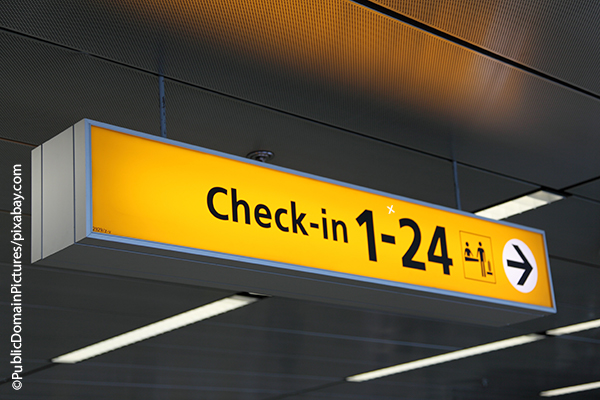 Wegweiser zu Check-in-Schaltern an einem Flughafen 