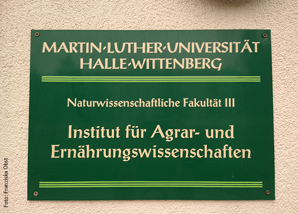 KI generiert: Das Bild zeigt ein Schild der Martin-Luther-Universität Halle-Wittenberg, das das Institut für Agrar- und Ernährungswissenschaften der Naturwissenschaftlichen Fakultät III bezeichnet. Der Hintergrund des Schildes ist grün mit weißer Schrift.