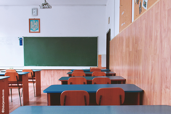 Leeres Klassenzimmer mit Sitzreihen und Tafel.