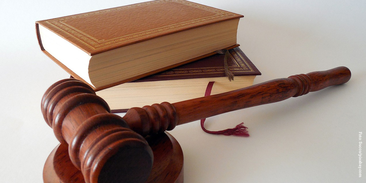 KI generiert: Das Bild zeigt einen Richterhammer aus Holz und zwei Bücher, die aufeinander gestapelt sind. Der Hauptinhalt des Bildes ist das Thema Recht und Justiz.