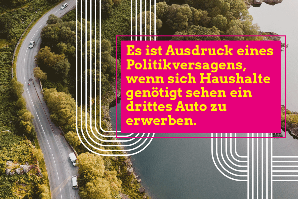 Ein Foto aus der Vogelperspektive zeigt eine Landstraße, die zwischen einem Wald und einem See hindurchführt. Darauf befindet sich ein Text: Es ist Ausdruck eines Politikversagens, wenn sich Haushalte genötigt sehen ein drittes Auto zu erwerben."