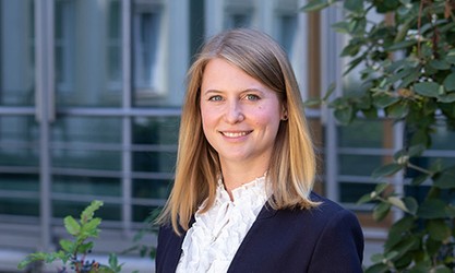 Levke Feddersen steht vor einer Gebäudestruktur und schaut in die Kamera.
